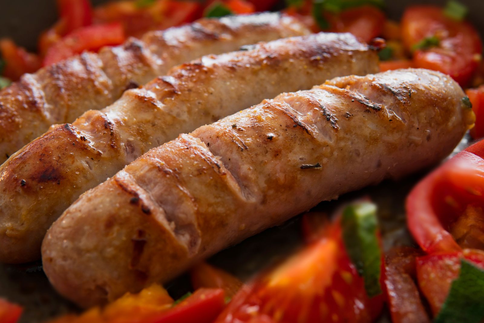 Gegrillte Bratwürste mit Tomaten und Paprika in der Pfanne