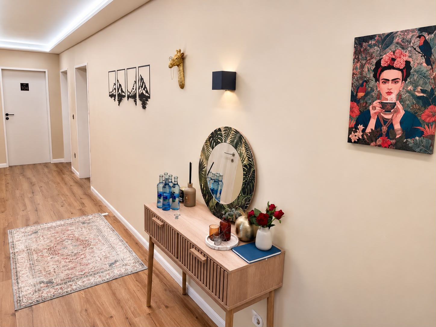 Heller Flur der Villa Johannes mit Sideboard, Spiegel, Blumen und Bildern an der Wand
